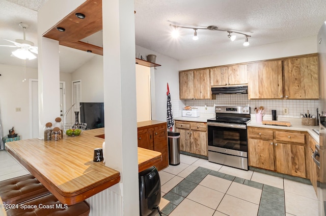 kitchen with stainless steel range with electric stovetop, decorative backsplash, and light tile patterned floors