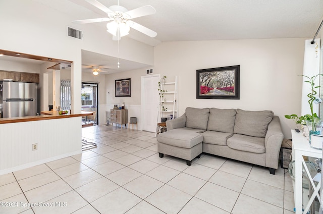 living room featuring light tile patterned floors, vaulted ceiling, and ceiling fan