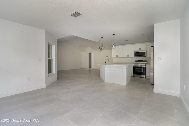 kitchen featuring visible vents, stainless steel appliances, light countertops, white cabinetry, and open floor plan