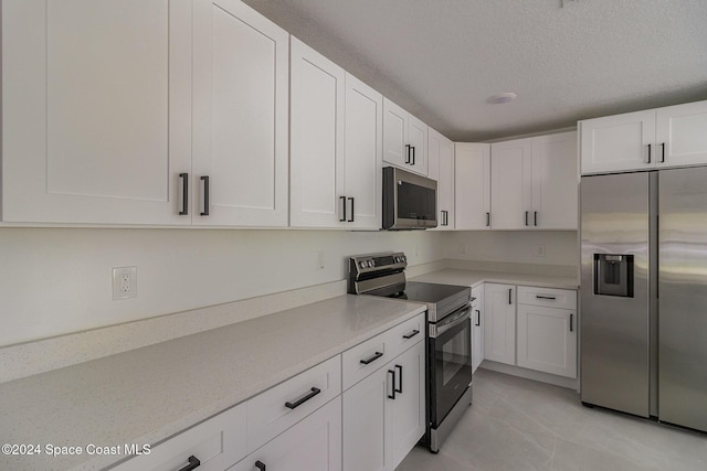 963 Sareta St SE, Palm Bay, FL 32909 - kitchen featuring appliances with stainless steel finishes, light countertops, white cabinets, and a textured ceiling