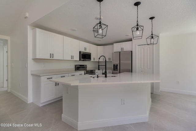 kitchen featuring a center island with sink, white cabinets, a textured ceiling, and appliances with stainless steel finishes