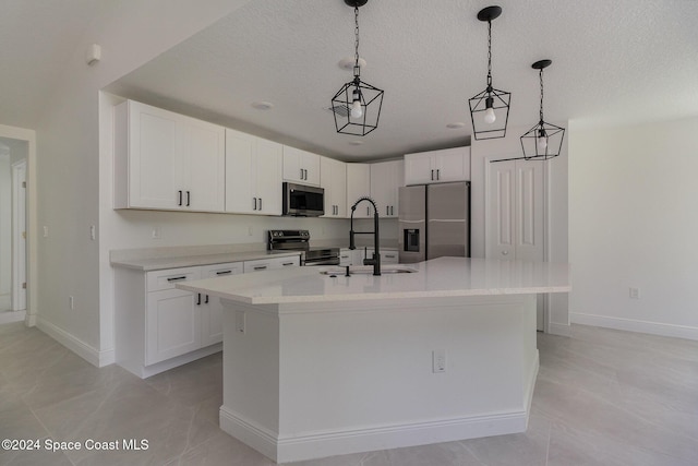 963 Sareta St SE, Palm Bay, FL 32909 - kitchen with stainless steel appliances, light countertops, white cabinetry, a kitchen island with sink, and a textured ceiling