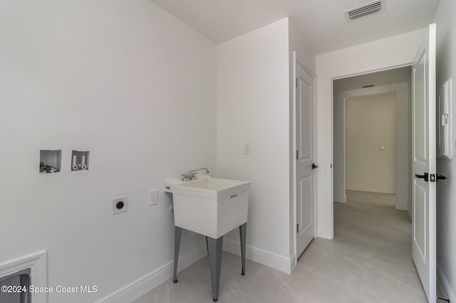 washroom with electric dryer hookup, visible vents, baseboards, hookup for a washing machine, and laundry area