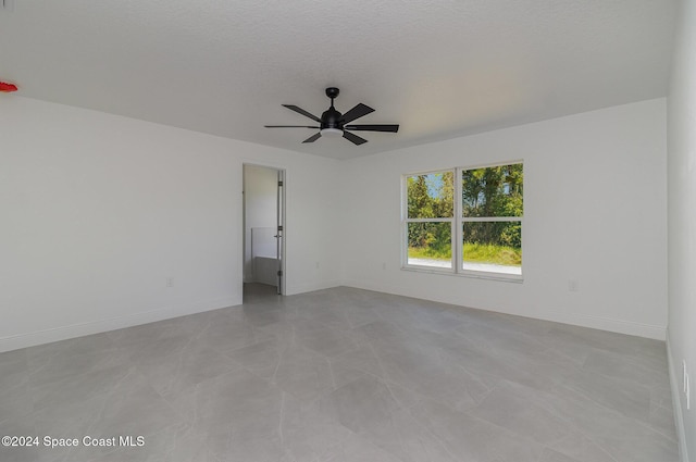 empty room with a textured ceiling and ceiling fan