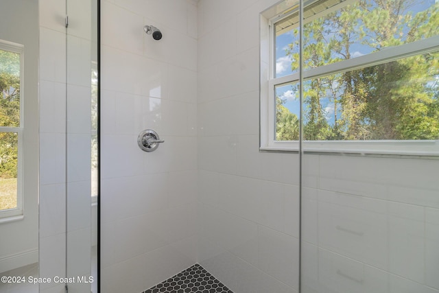 bathroom featuring a tile shower and a wealth of natural light