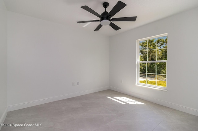 spare room featuring baseboards, plenty of natural light, and a ceiling fan