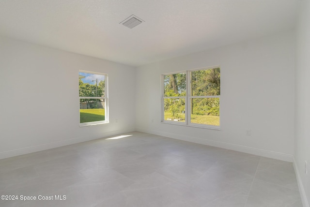 empty room with a healthy amount of sunlight and a textured ceiling