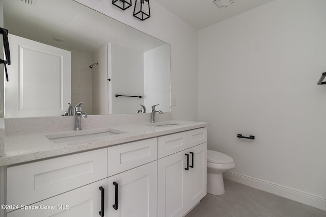 full bathroom featuring a sink, toilet, double vanity, and tile patterned flooring