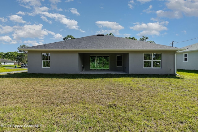 963 Sareta St SE, Palm Bay, FL 32909 - rear view of property featuring stucco siding, a patio area, and a lawn