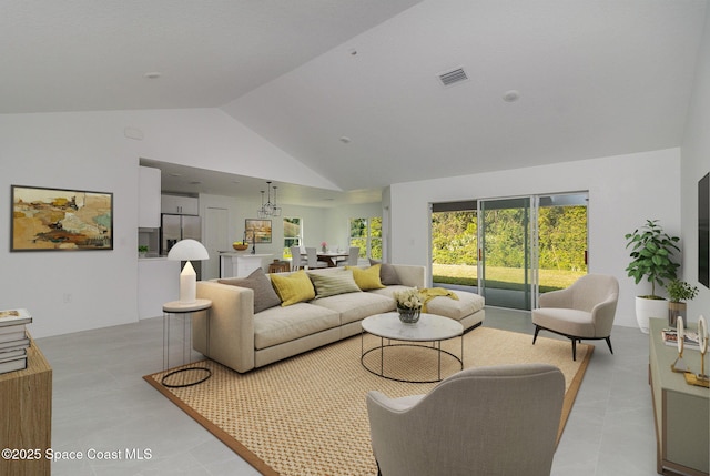 living area with light tile patterned floors, baseboards, visible vents, and high vaulted ceiling