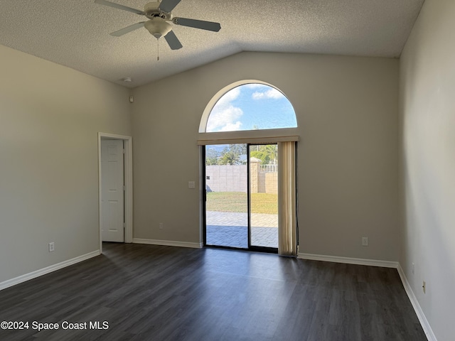 empty room with a textured ceiling, ceiling fan, dark wood-type flooring, and vaulted ceiling