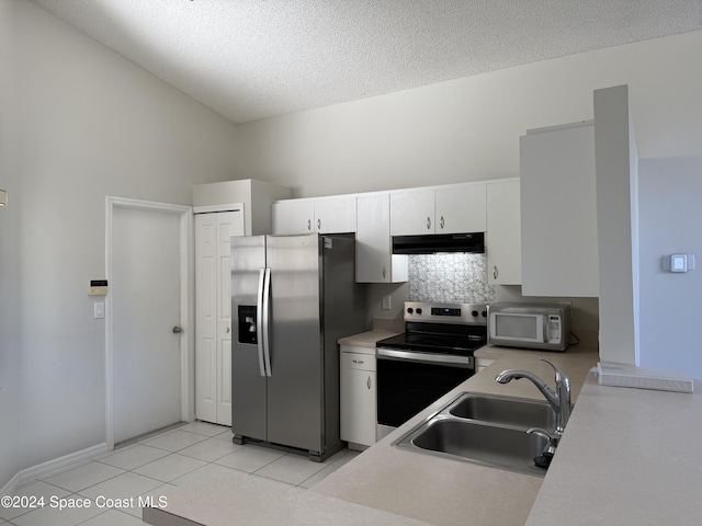 kitchen with sink, white cabinets, high vaulted ceiling, light tile patterned flooring, and appliances with stainless steel finishes