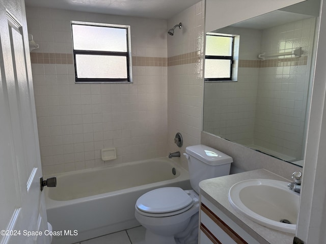 full bathroom featuring tile patterned floors, vanity, tiled shower / bath combo, and toilet