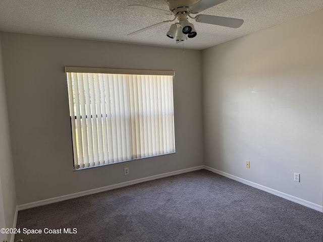 carpeted spare room featuring ceiling fan and a textured ceiling