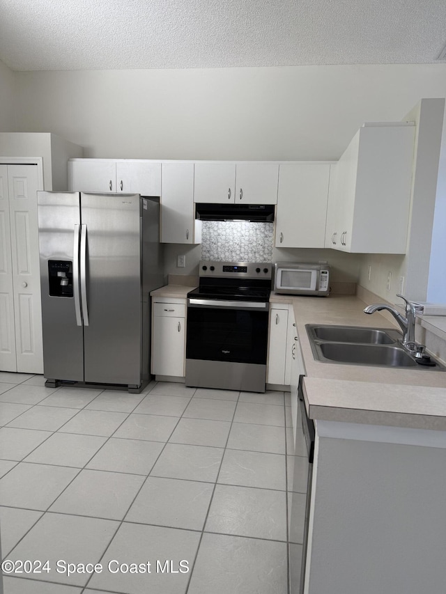 kitchen with sink, white cabinets, stainless steel appliances, and light tile patterned floors