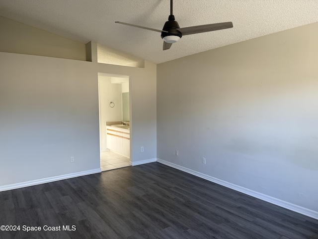 spare room with a textured ceiling, dark hardwood / wood-style flooring, ceiling fan, and lofted ceiling