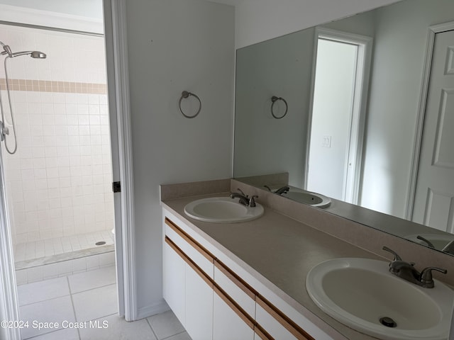 bathroom featuring tile patterned flooring, vanity, and tiled shower