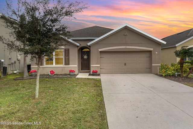 single story home with a garage and a yard