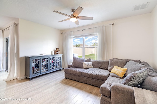 living room with ceiling fan and light hardwood / wood-style flooring