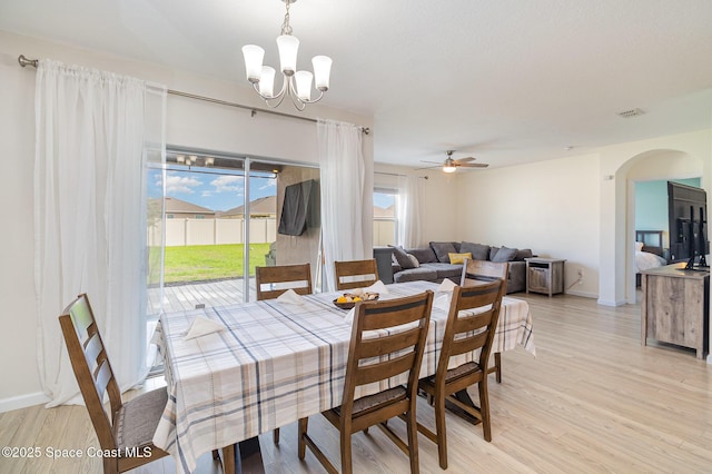 dining space featuring ceiling fan with notable chandelier and light hardwood / wood-style floors