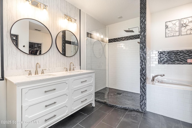 bathroom with tile patterned floors, vanity, tile walls, and plus walk in shower