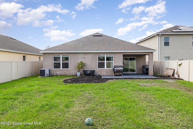 back of property with a patio, central AC, and a lawn