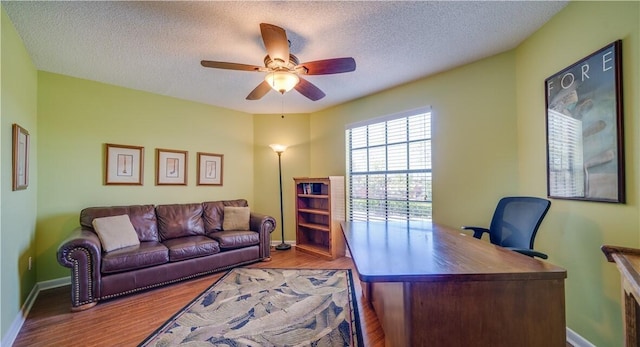 home office with ceiling fan, a textured ceiling, and light wood-type flooring