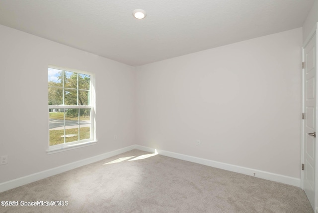 unfurnished room featuring light carpet