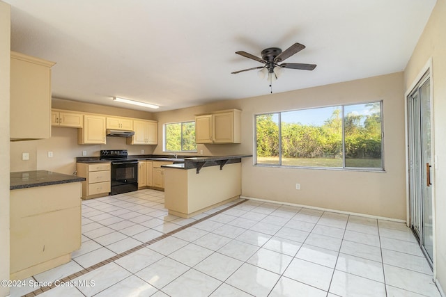 kitchen with a breakfast bar, black range with electric stovetop, ceiling fan, light tile patterned floors, and kitchen peninsula