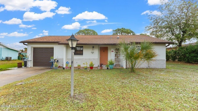 ranch-style house featuring a front yard, a garage, and central AC unit