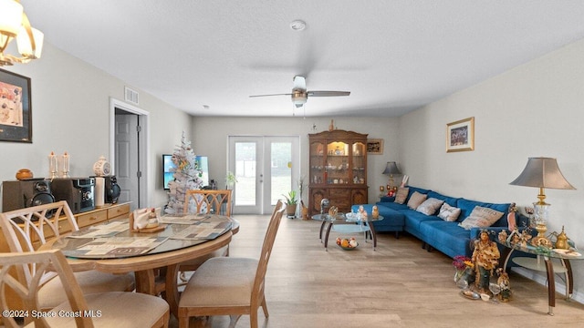 dining area featuring ceiling fan, french doors, and light hardwood / wood-style floors