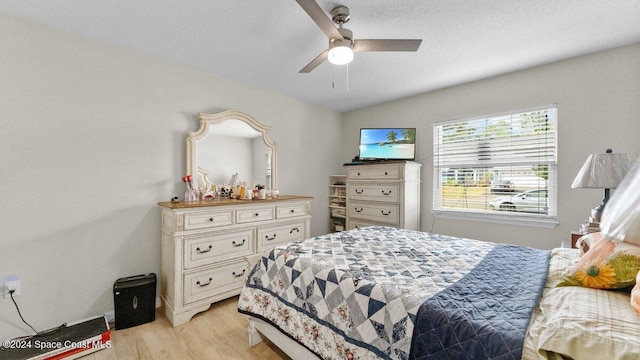 bedroom featuring ceiling fan, light wood-type flooring, and vaulted ceiling