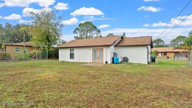 rear view of property featuring french doors and a yard