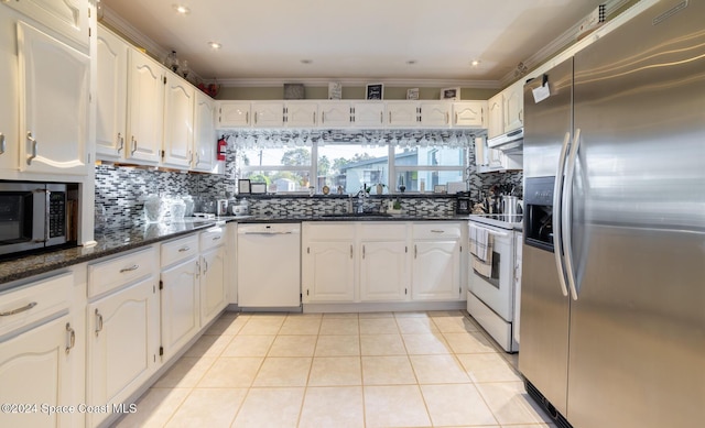 kitchen with white cabinets, white appliances, crown molding, and dark stone countertops