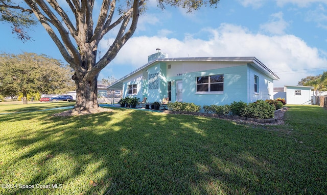 view of front of property with a front lawn and a shed