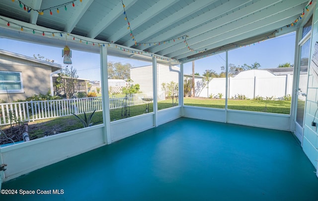 unfurnished sunroom with beam ceiling