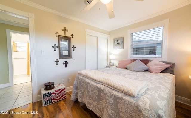 bedroom with ceiling fan, ornamental molding, dark wood-type flooring, and a closet