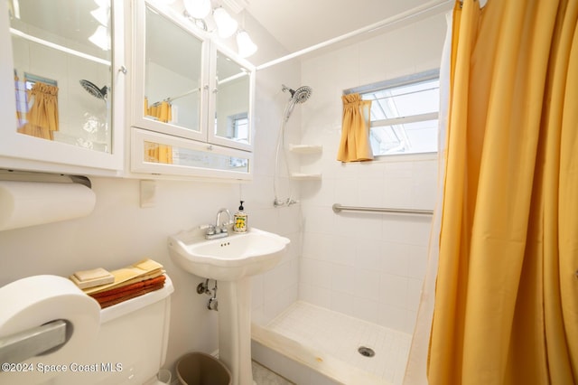 bathroom with a shower with curtain, toilet, and sink