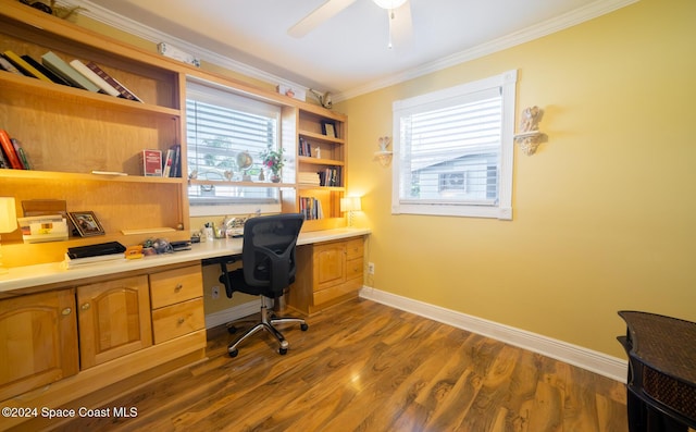 office with dark wood-type flooring, crown molding, plenty of natural light, and built in desk