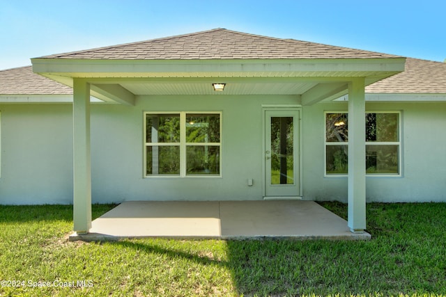 back of property with a lawn and a patio area