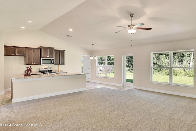 kitchen with appliances with stainless steel finishes, light colored carpet, and vaulted ceiling