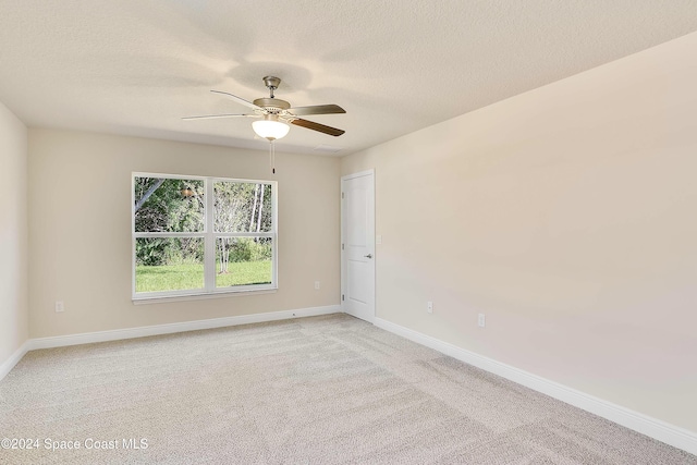 carpeted empty room with ceiling fan and a textured ceiling