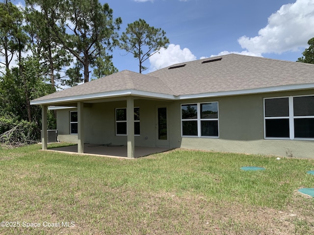 698 De Groodt Rd SW, Palm Bay, FL 32908 - back of property featuring stucco siding, a patio, a lawn, and a shingled roof