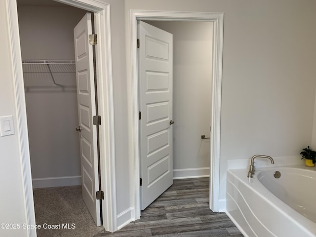 698 De Groodt Rd SW, Palm Bay, FL 32908 - full bath with a garden tub, wood finished floors, and a spacious closet