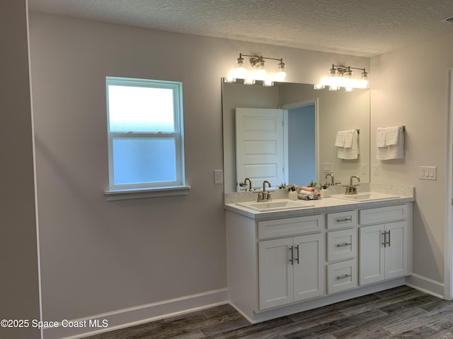 698 De Groodt Rd SW, Palm Bay, FL 32908 - full bath featuring wood finished floors, double vanity, and a textured ceiling