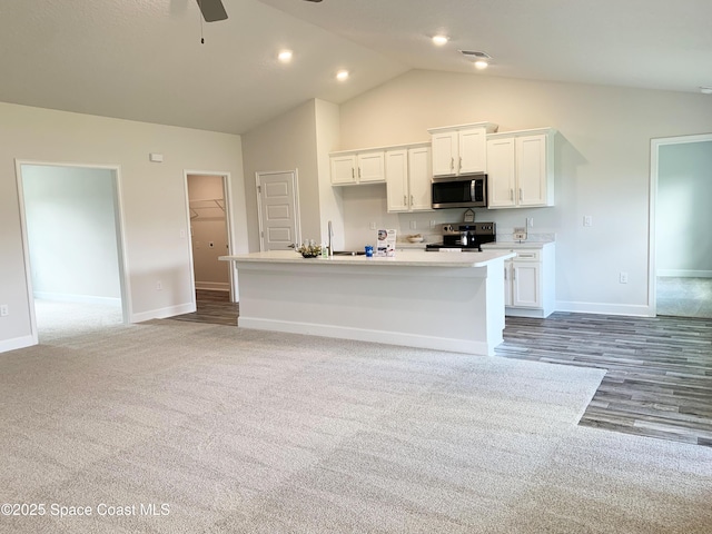 698 De Groodt Rd SW, Palm Bay, FL 32908 - kitchen featuring stainless steel microwave, electric range oven, white cabinets, ceiling fan, and high vaulted ceiling