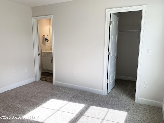 698 De Groodt Rd SW, Palm Bay, FL 32908 - unfurnished bedroom featuring carpet, a walk in closet, a closet, and connected bathroom