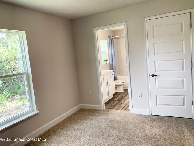 698 De Groodt Rd SW, Palm Bay, FL 32908 - unfurnished bedroom with carpet flooring, multiple windows, and ensuite bathroom