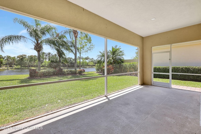 unfurnished sunroom featuring a water view