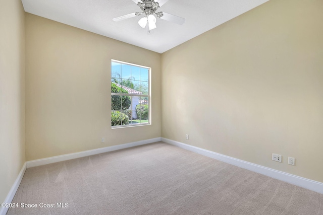 spare room with light colored carpet and ceiling fan